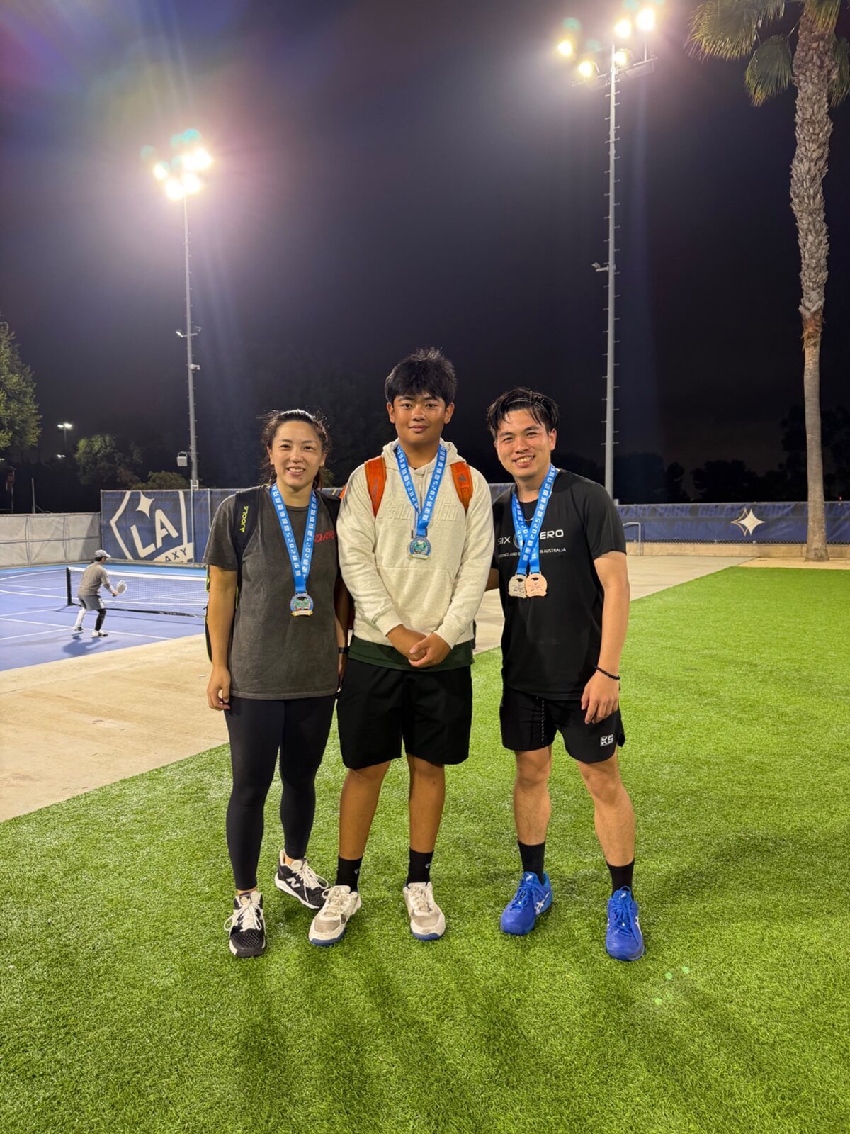 Athletes and mentors displaying medals after a night tournament