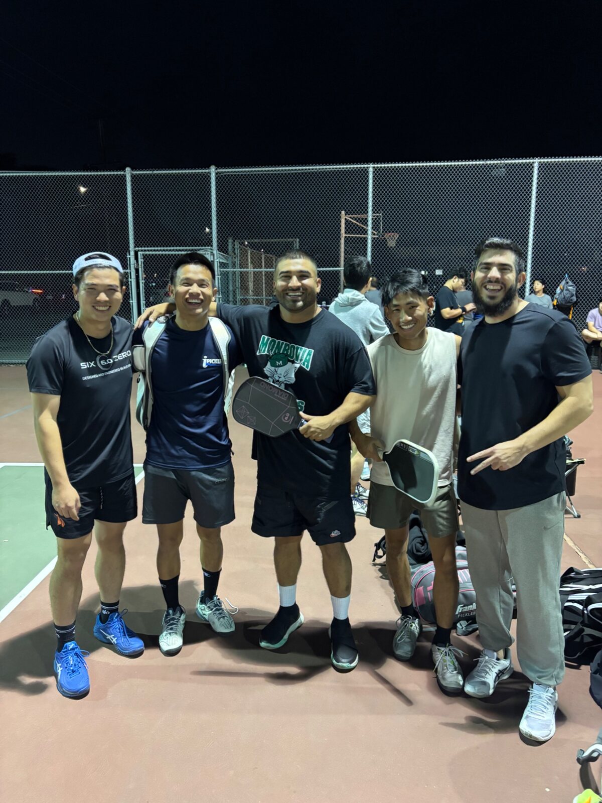 Players smiling together during a nighttime community event
